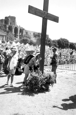Una joven besa, después de confesarse, la Cruz de los jóvenes instalada en el centro del Circo Massimo