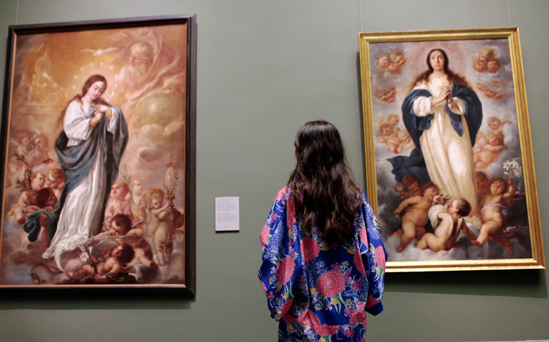 Una visitante observa a la derecha la 'Inmaculada' de Francisco de Herrera el Mozo y a la izquierda la representación de Juan de Valdés Leal
