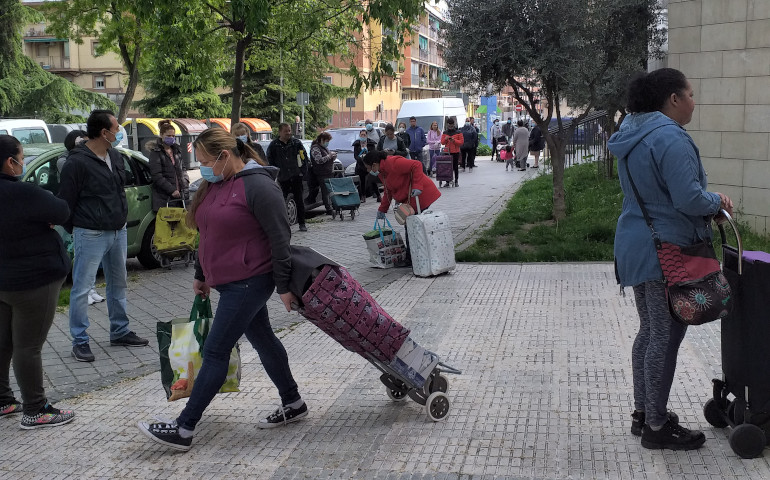 Un grupo de personas en la fila para el reparto de alimentos, en la parroquia de Santa Catalina Labouré de Madrid