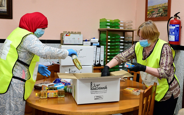 Hakima, a la izquierda, prepara junto a otra voluntaria unas cajas con alimentos en la Asociación Nazaret de Madrid