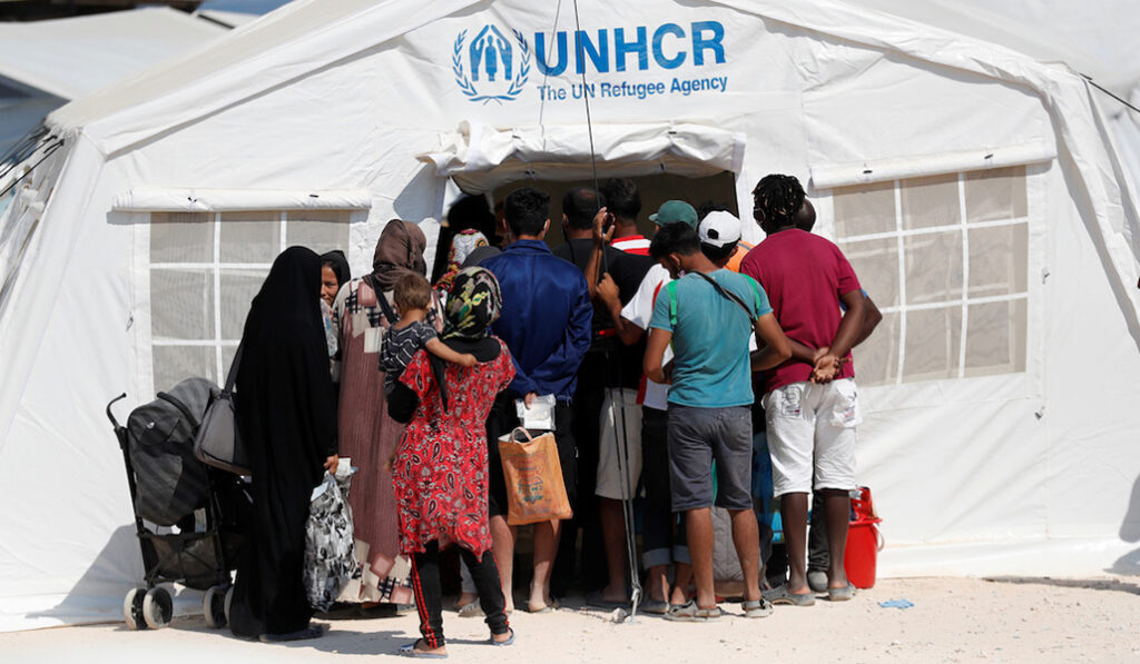 Refugiados y migrantes del destruido campamento de Moria se reúnen fuera de una tienda de campaña de ACNUR en un nuevo campamento temporal en la isla de Lesbos, Grecia, el 21 de septiembre de 2020