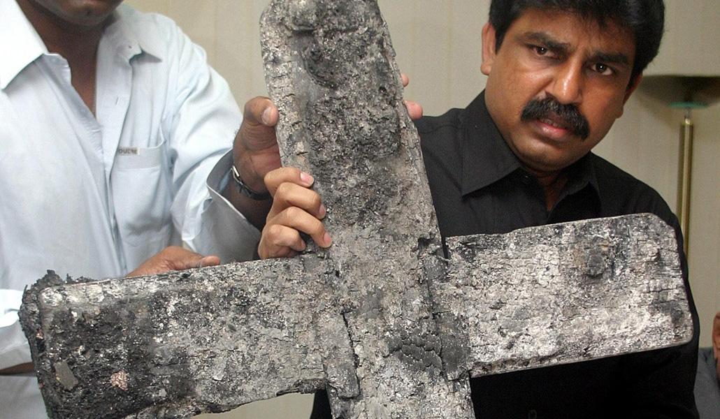 Shahbaz Bhatti muestra la cruz quemada en el ataque a una iglesia, en 2005