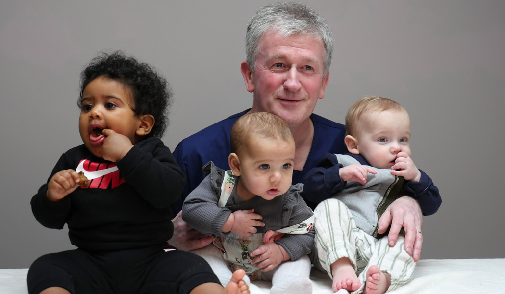 El doctor Kearney posa con tres niños a los que salvó
