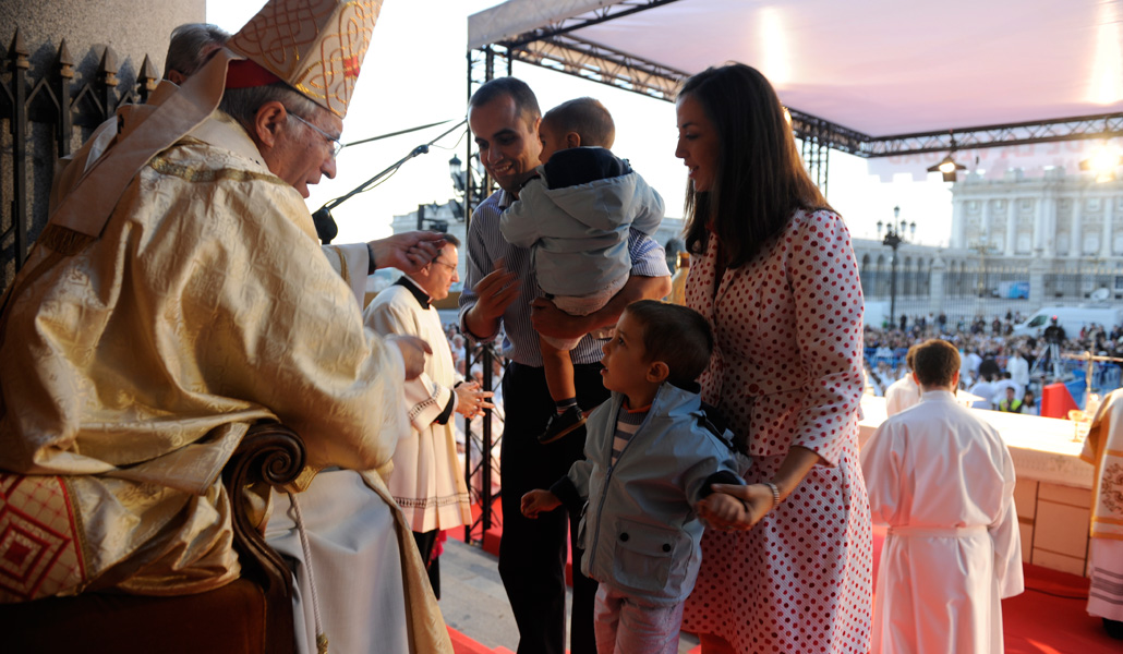 El cardenal Rouco entrega la cruz evangelizadora a una familia, en la Eucaristía de inicio de la Misión Madrid