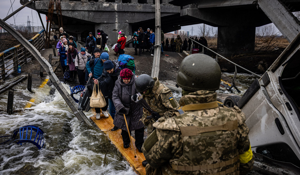 Ucranianos evacuados cruzan un puente destruido mientras huyen de la ciudad de Irpin, al noroeste de Kiev, el pasado 7 de marzo