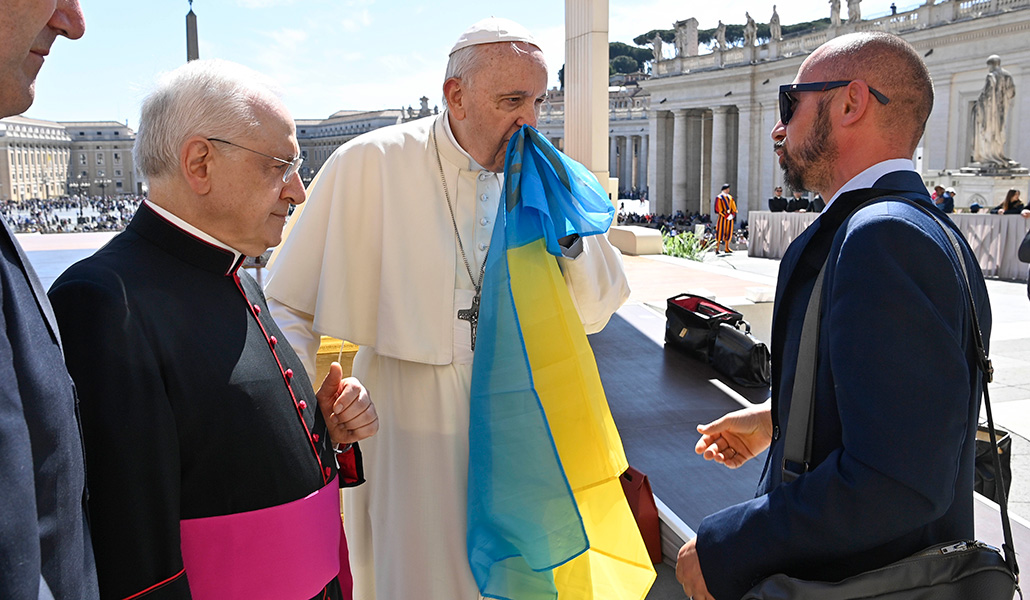 El Papa Francisco besa la bandera de Ucrania durante un encuentro con un grupo de refugiados ucranianos, en la plaza de San Pedro