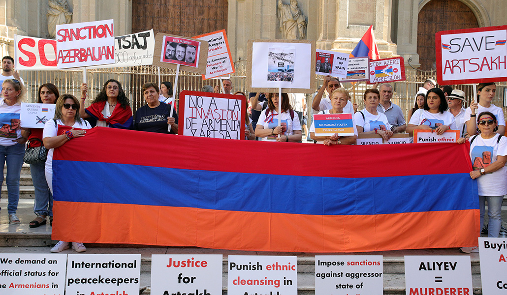 Personas manifestándose con una bandera armenia por Nagorno Karabaj