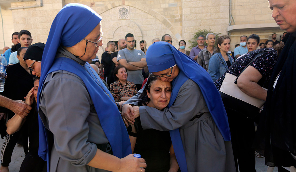 La hermana María del Pilar Llerena abraza a una familiar de un fallecido durante el funeral en San Porfirio