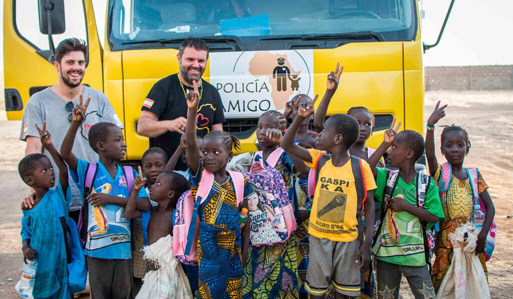 Niños de Bukina Faso ante un camión de Policía Amigo