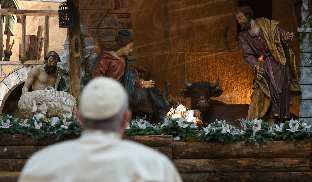 El Papa Francisco en oración ante el belén, al finalizar la Misa del Gallo, en la basílica de San Pedro del Vaticano, en 2022