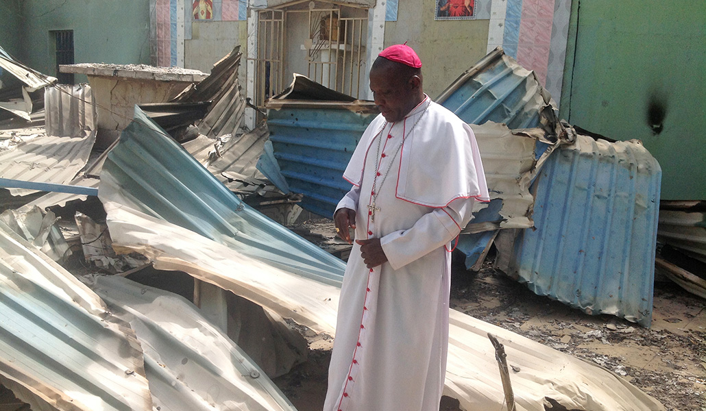 El obispo inspecciona una iglesia quemada en la comunidad de Bahuli (estado de Borno) en abril del año 2015