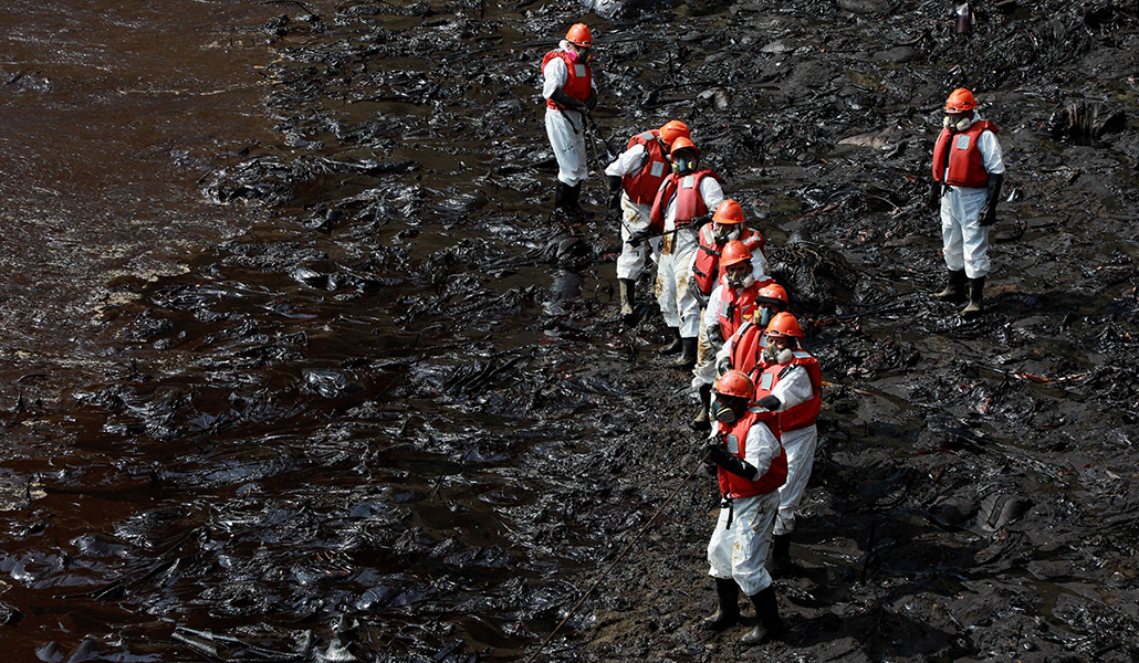 Trabajadores realizan labores de limpieza en las playas de Ventanilla, Perú, el 25 de enero de 2022, tras el vertido de petróleo