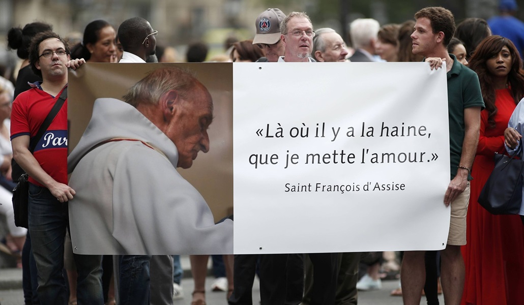 Fieles con un cartel del padre Jacques Hamel frente a la catedral de Notre Dame en 2016