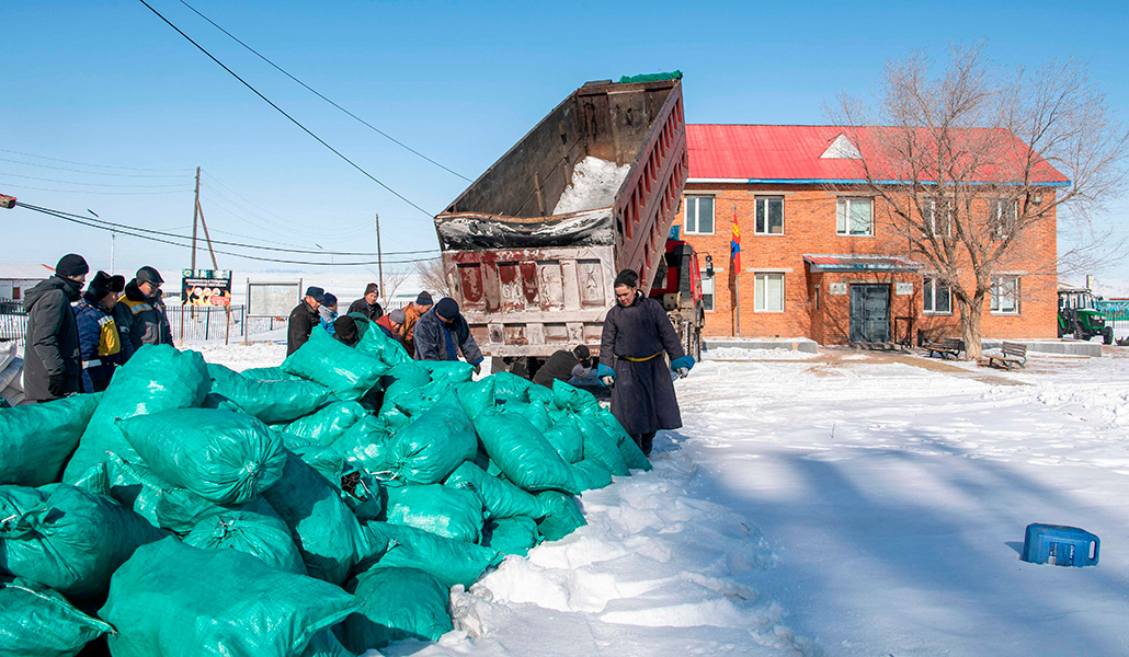 Pastores recibiendo sacos de carbón en medio de condiciones climáticas extremadamente frías en Bayanmunkh, Mongolia