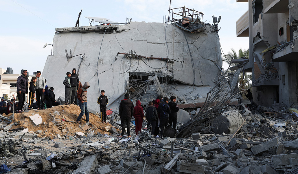 Palestinos se reúnen cerca de una casa alcanzada por un ataque israelí, en Rafah, en el sur de la Franja de Gaza, el 16 de febrero de 2024. Foto: Reuters /Ibraheem Abu Mustafa.