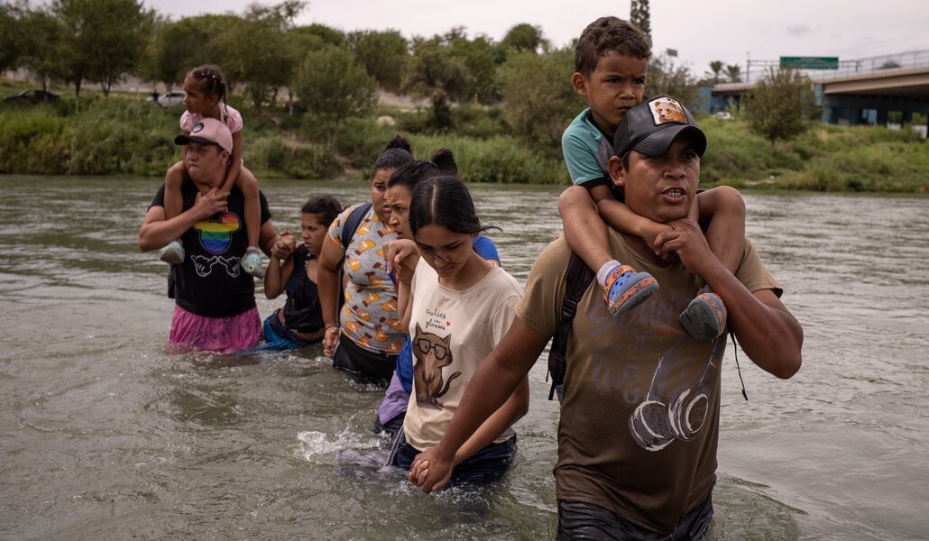 Un migrante ecuatoriano cruza el Río Grande con su familia