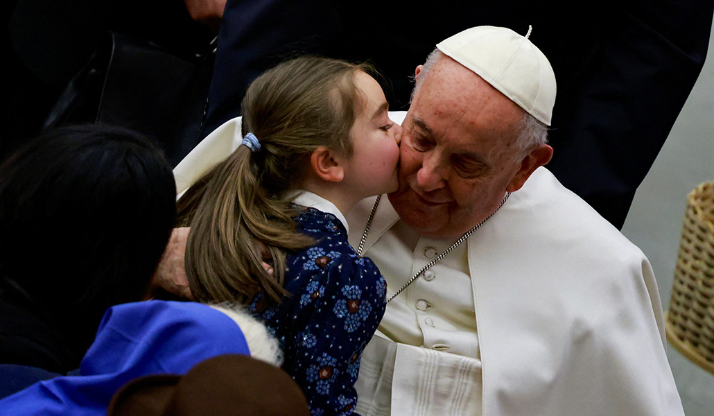 Una niña besa al Papa Francisco durante la audiencia general