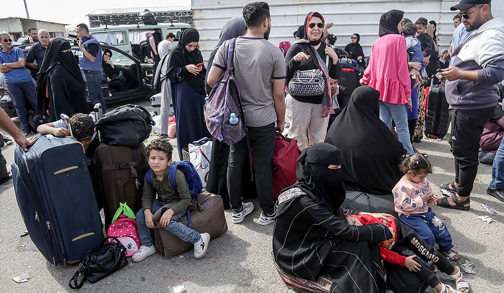 Palestinos esperan para cruzar el paso fronterizo de Rafah con Egipto