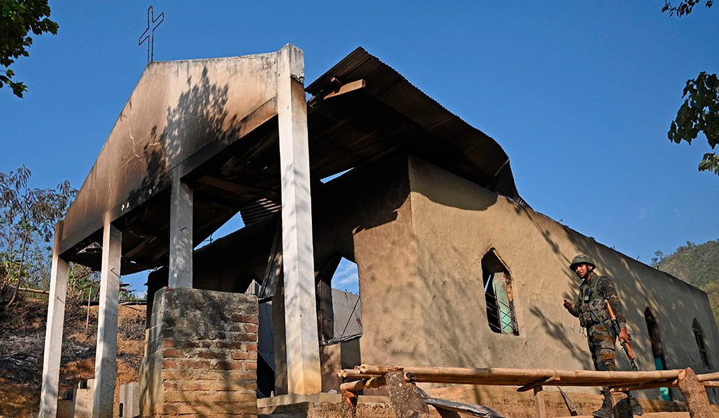 Un soldado del ejército indio en el exterior de una iglesia incendiada en Senapati, India
