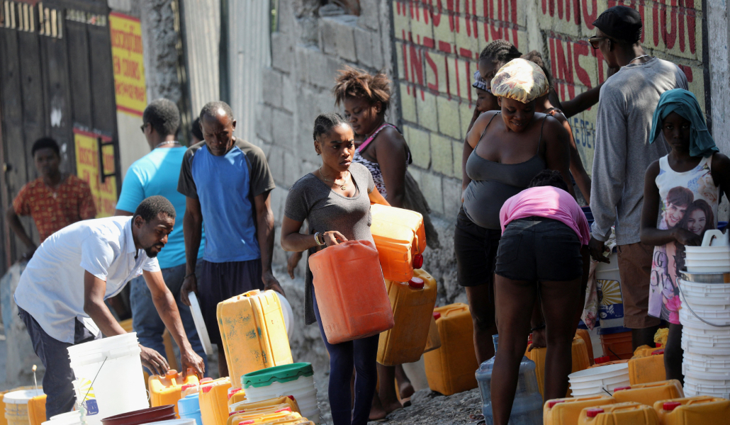 Vecinos de Haití llenando cubos de agua en Puerto Príncipe el 12 de marzo
