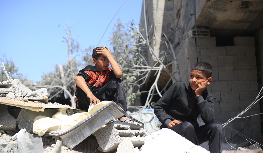 Unos niños palestinos se sientan en medio de la destrucción tras un bombardeo de aviones de combate israelíes en el centro de la ciudad de Rafah el martes 2 de abril de 2024
