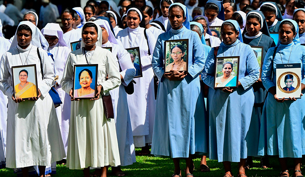 Unas religiosas llevan fotos de las víctimas asesinadas en los atentados del Domingo de Pascua de 2019, en la iglesia de San Sebastián de Katuwapitiya en Negombo el 21 de abril de 2024