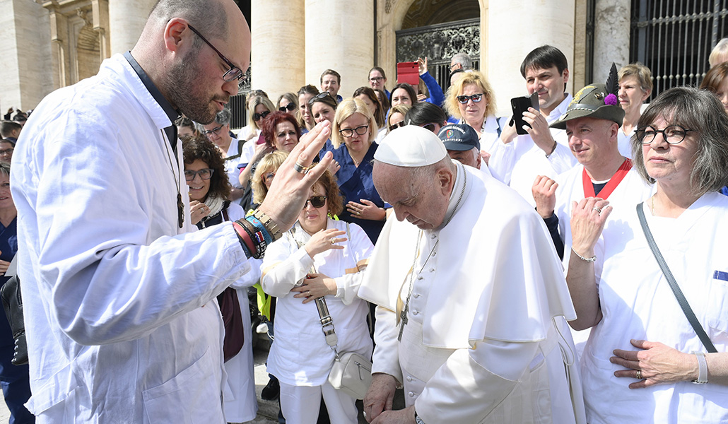 El Papa recibe la bendición de un capellán hospitalario durante una audiencia el año pasado
