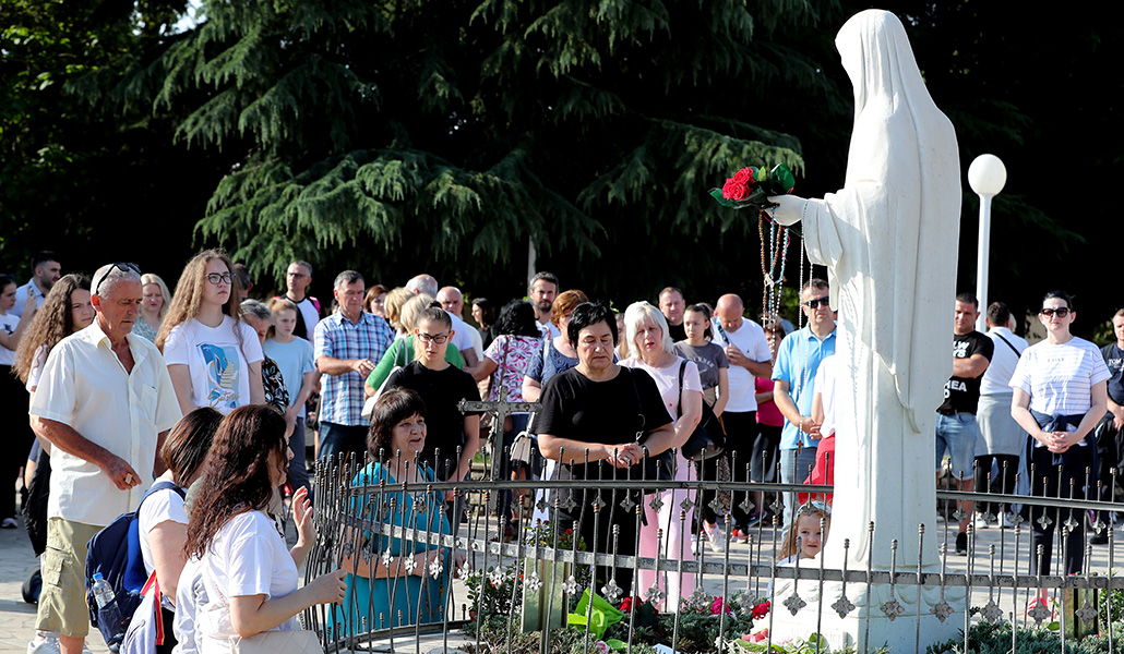 Peregrinos rezan frente a la estatua de la Virgen en Medjugorje