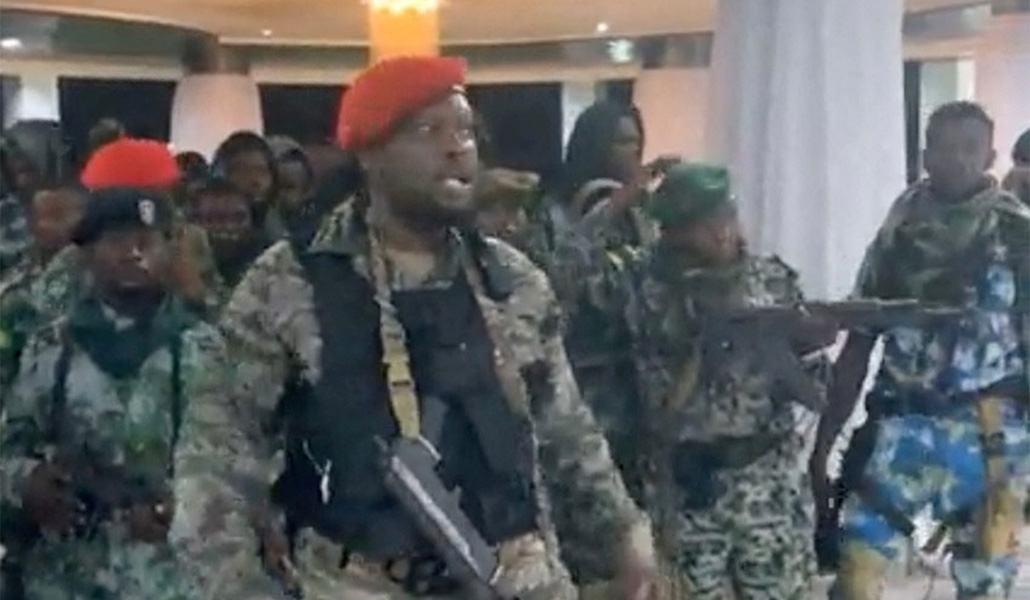 Un hombre con uniforme militar habla mientras otros están a su lado dentro del Palacio de la Nación durante un intento de golpe de Estado en Kinshasa, República Democrática del Congo, el 19 de mayo de 2024