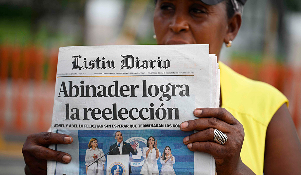 Una mujer vende periódicos nacionales en la calle un día después de las elecciones presidenciales en Santo Domingo, el 20 de mayo de 2024