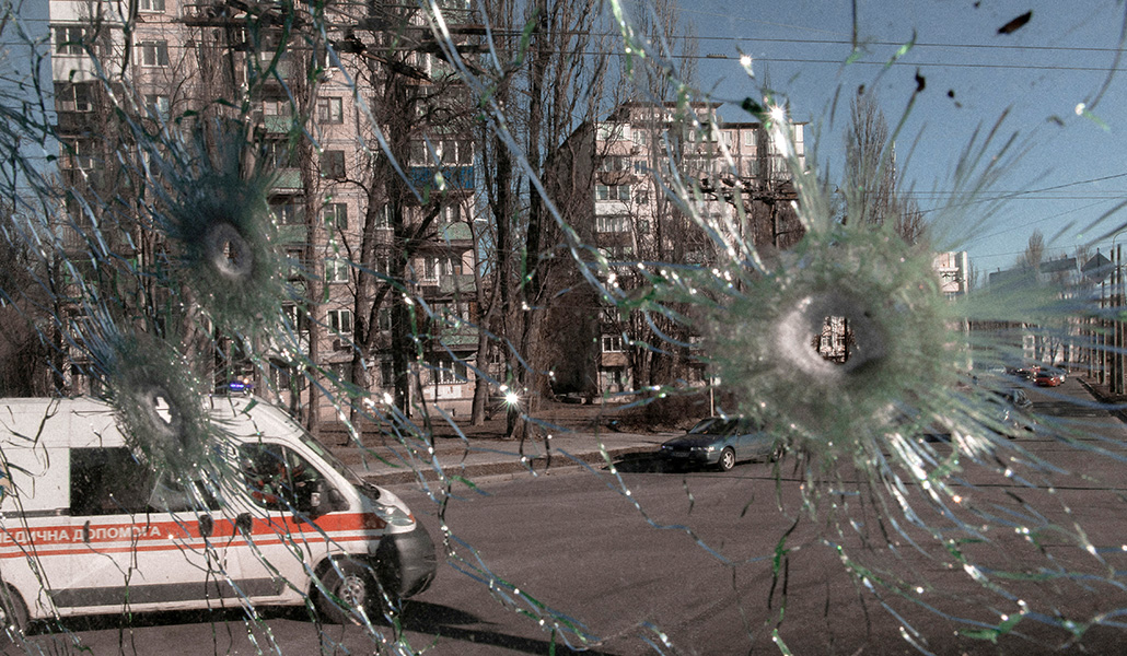 Una ambulancia es vista a través de un cristal de un vehículo alcanzado por balas, en Kiev (Ucrania)