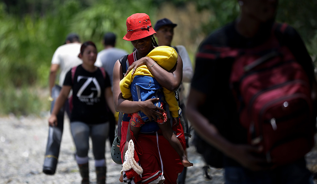 Una mujer haitiana migra con su hijo en la selva del Darién (Panamá)