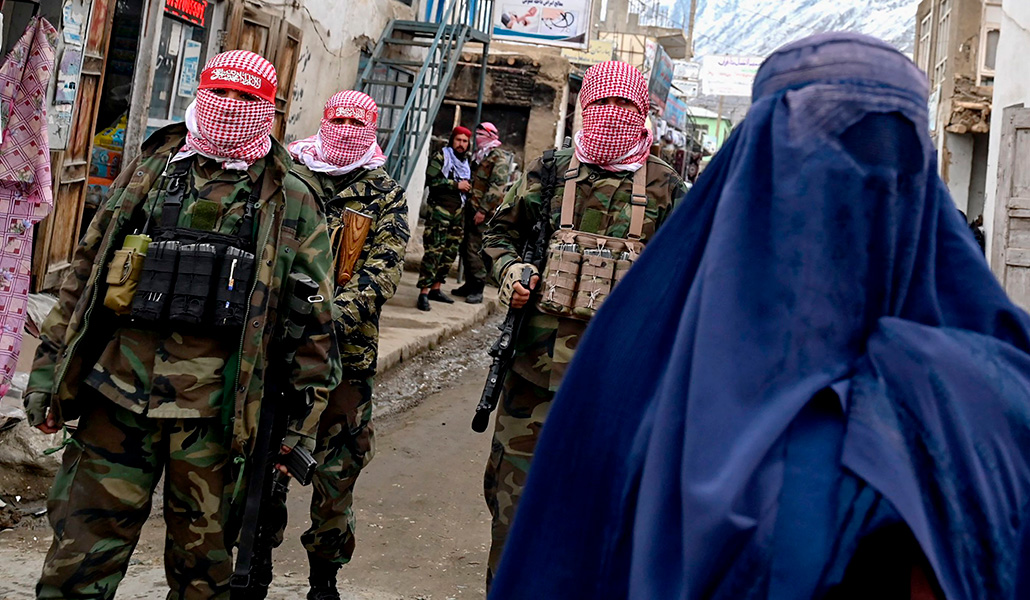 Unos talibanes junto a una mujer en el mercado de Baharak, Afganistán