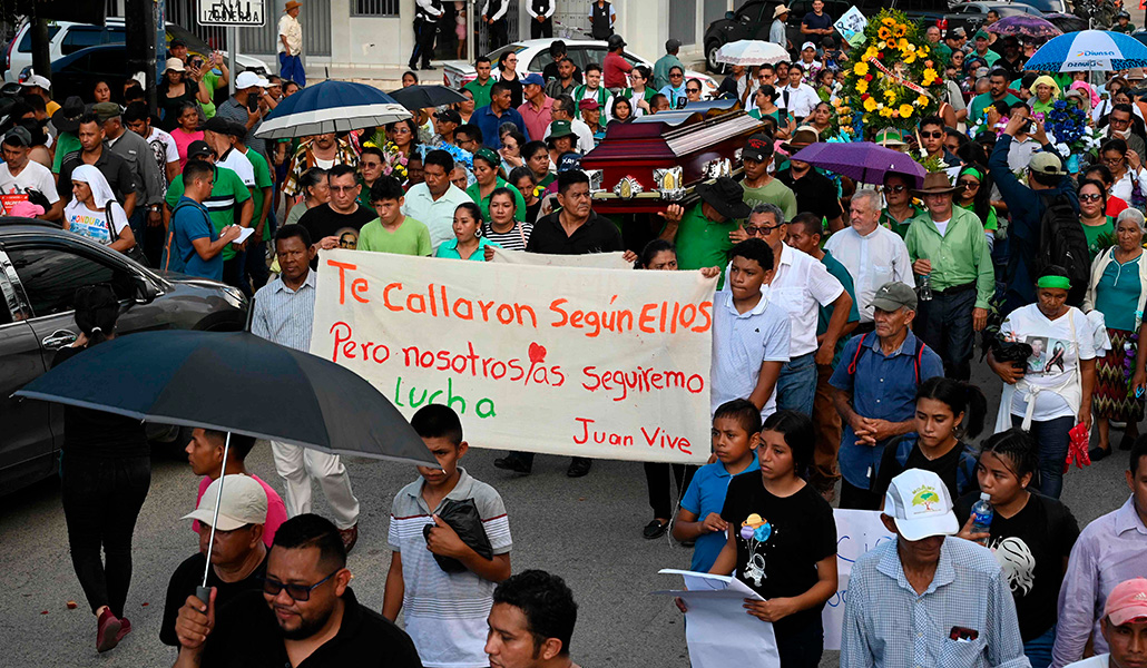 La gente sostiene una pancarta en la que se lee: «Te callaron, según ellos. Pero continuaremos su lucha» durante el funeral del líder ambientalista Juan López en el municipio de Tocoa, departamento de Colón, Honduras, el 16 de septiembre de 2024