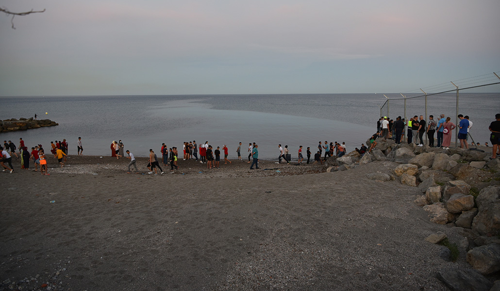 Migrantes caminan por la playa del Tarajal