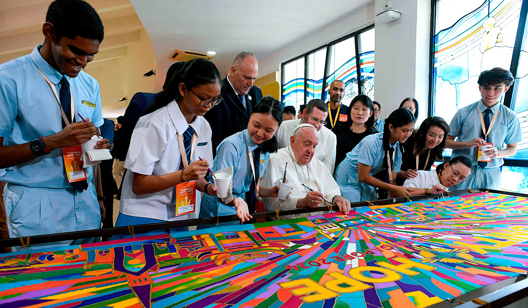 Francisco pinta un mural durante un encuentro con jóvenes en Singapur