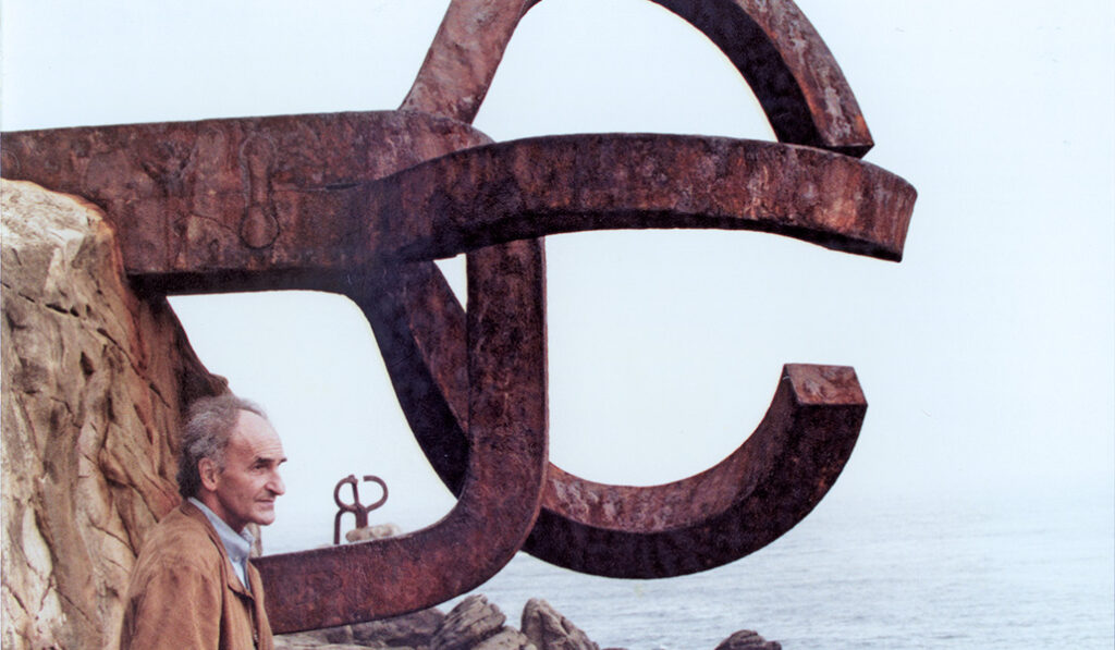 El artista donostiarra (1924-2002) junto a 'Peine del viento', en la playa de Ondarreta