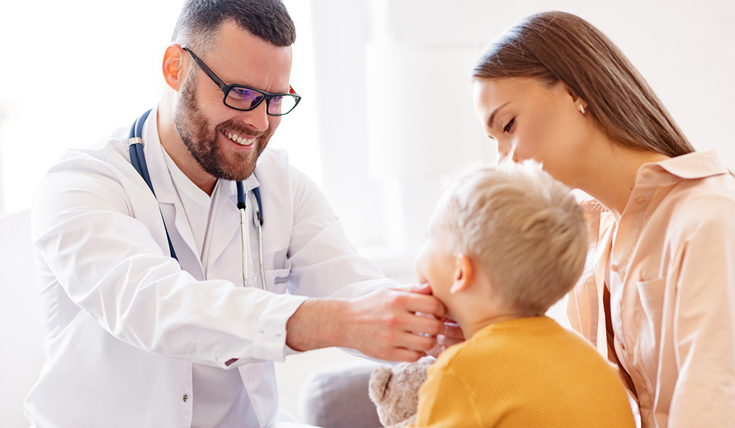 Un médico atiende a un niño en su consulta