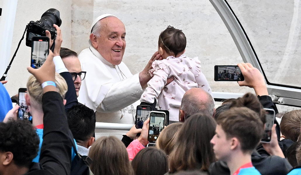 El Papa acaricia a un niño antes de la audiencia