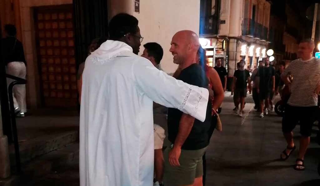 Un sacerdote habla con jóvenes a la puerta de la parroquia durante una evangelización