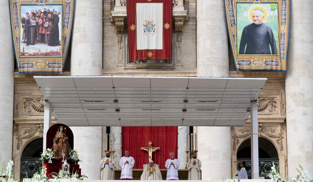 Francisco durante la ceremonia de canonización de 14 beatos, entre ellos, los 11 mártires de Damasco representados en los tapices que cuelgan de la fachada de la basílica de San Pedro