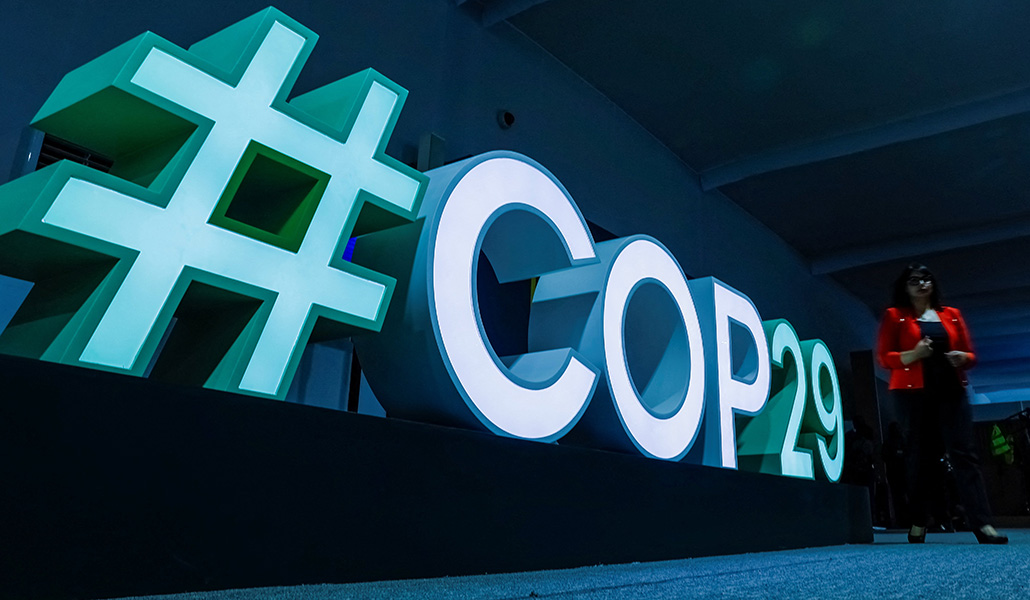 Una mujer pasa junto a un cartel #COP29 durante la conferencia de la ONU sobre cambio climático COP29 en Bakú, Azerbaiyán, el 11 de noviembre de 2024