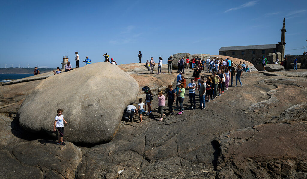 Los fieles pasan por debajo de la 'pedra dos cadrís' para pedir la sanación de alguna de sus dolencias