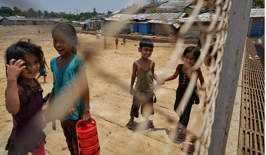 Niños rohinyás juegan más allá de la valla que delimita uno de los campamentos de Cox’s Bazar