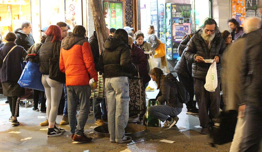 Personas sin hogar reciben alimento y abrigo en la calle Montera de Madrid