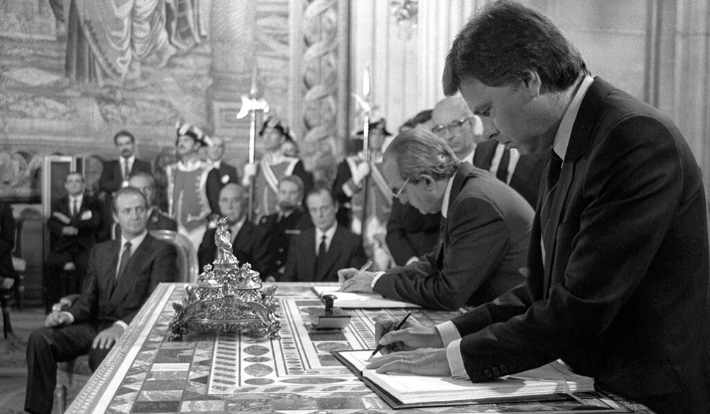 Felipe González, el entonces presidente del Gobierno, y el ministro de Exteriores, Fernando Morán, firman la adhesión de España a la Comunidad Económica Europea en presencia del rey Juan Carlos, en el Palacio Real.