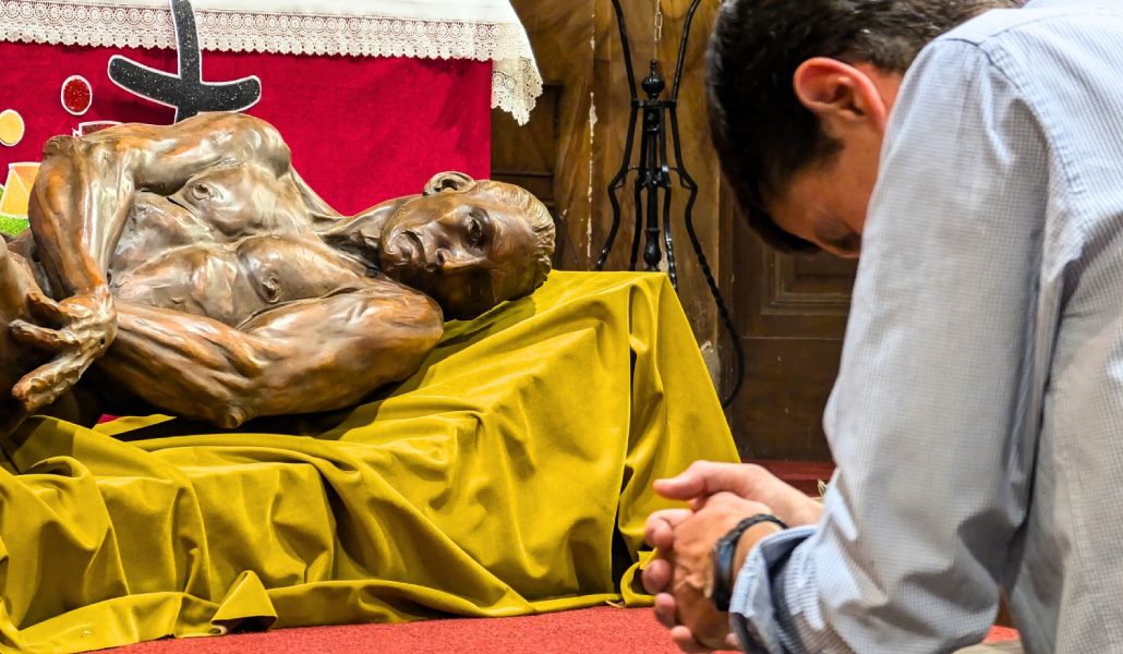 Un feligrés de la iglesia de San Antón reza ante 'Resurrectio', la imagen de Cristo resucitado