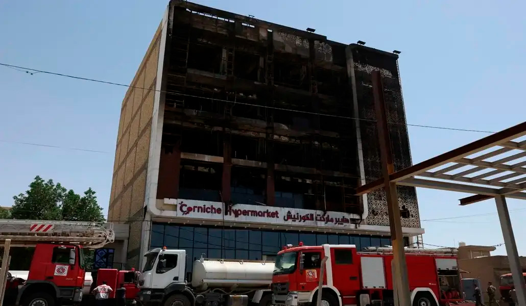 Camiones de bomberos junto al centro comercial que ha ardido.