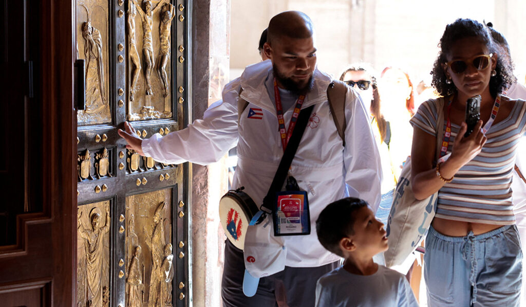 Los fieles graban el momento de entrar por la Puerta Santa.