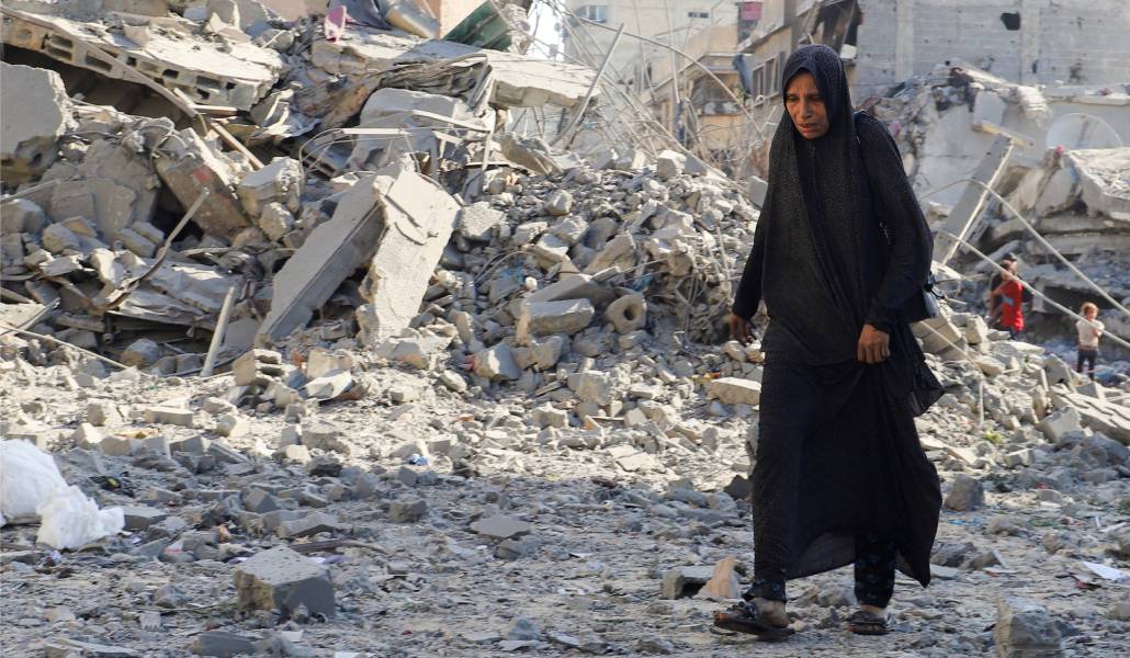 Una mujer camina por una zona donde se ha producido un ataque israelí en Gaza